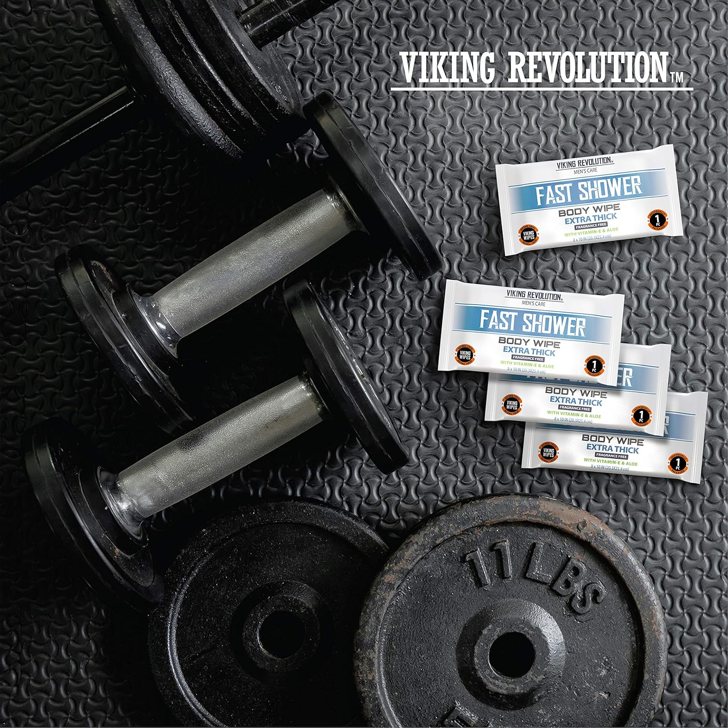 Two dumbbells, a weight plate, and four Body Wipes w/ Vitamin E & Aloe on a textured gym mat.