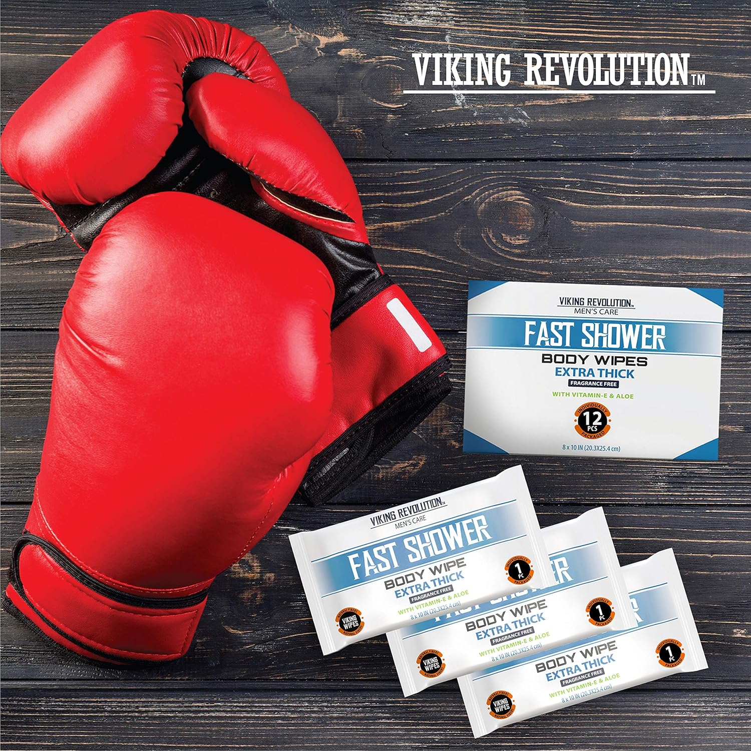 Red boxing gloves next to a 12-pack of Body Wipes w/ Vitamin E & Aloe on a dark wooden surface.