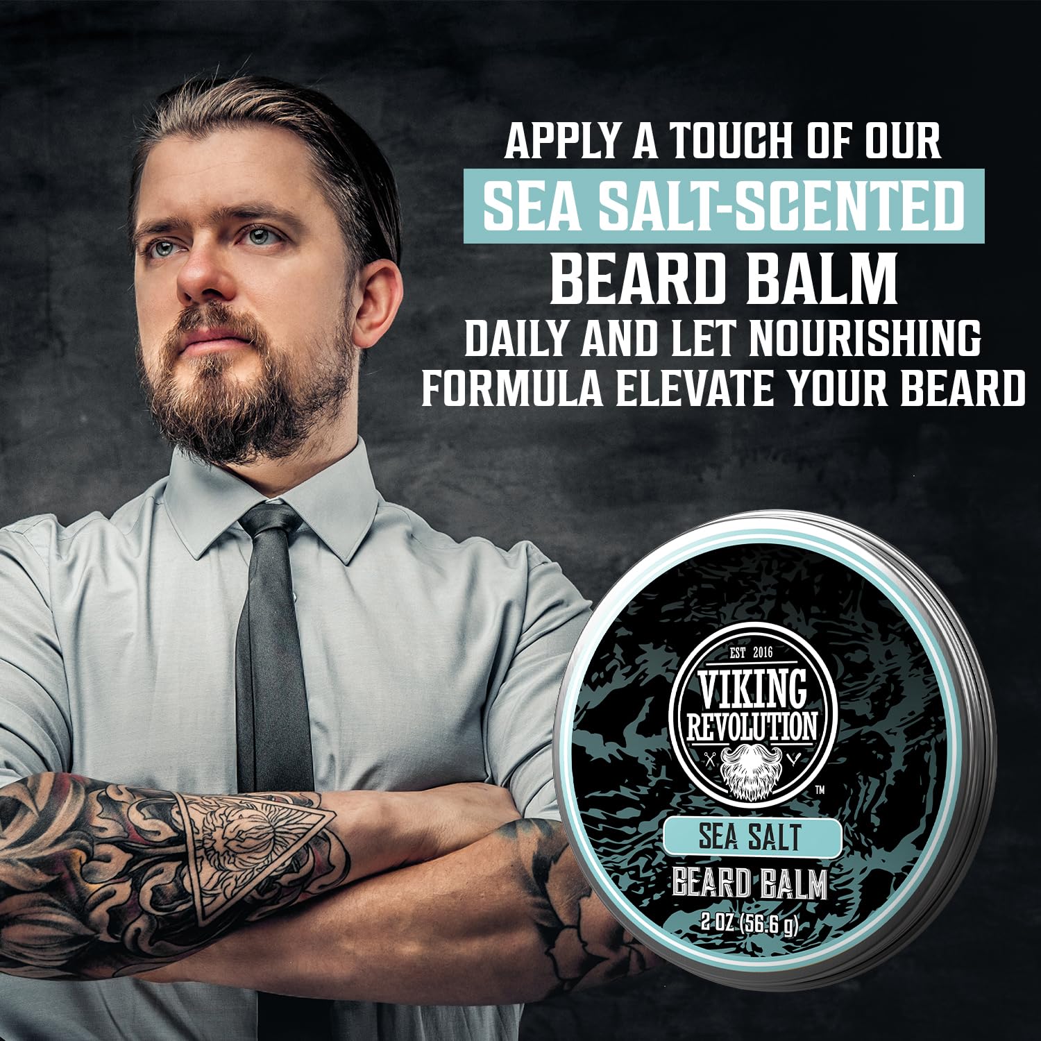 Tattooed man stands beside tin of Sea Salt Beard Balm (2 oz), the best for natural beard care.