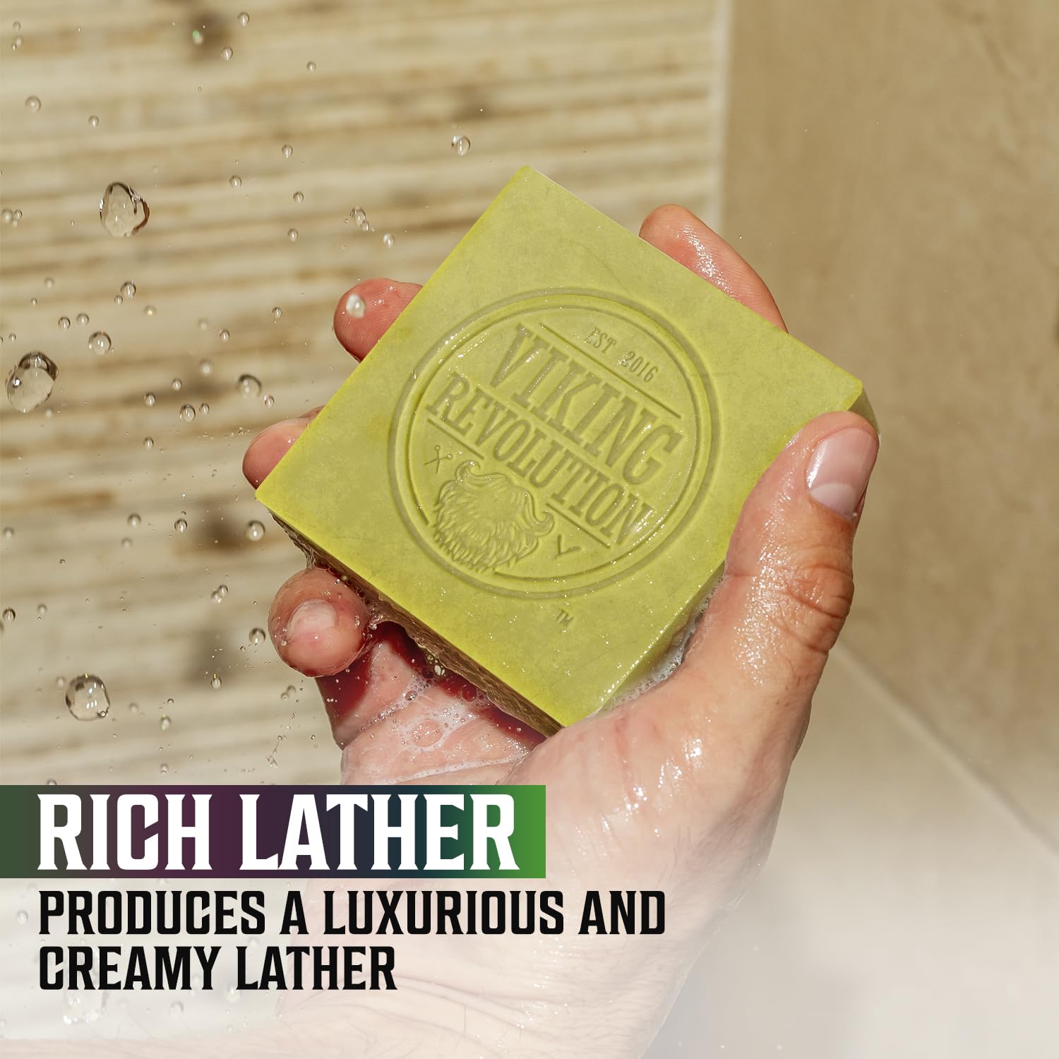 Hand holding a cold pressed Viking Revolution soap bar under invigorating water labeled Tea Tree.