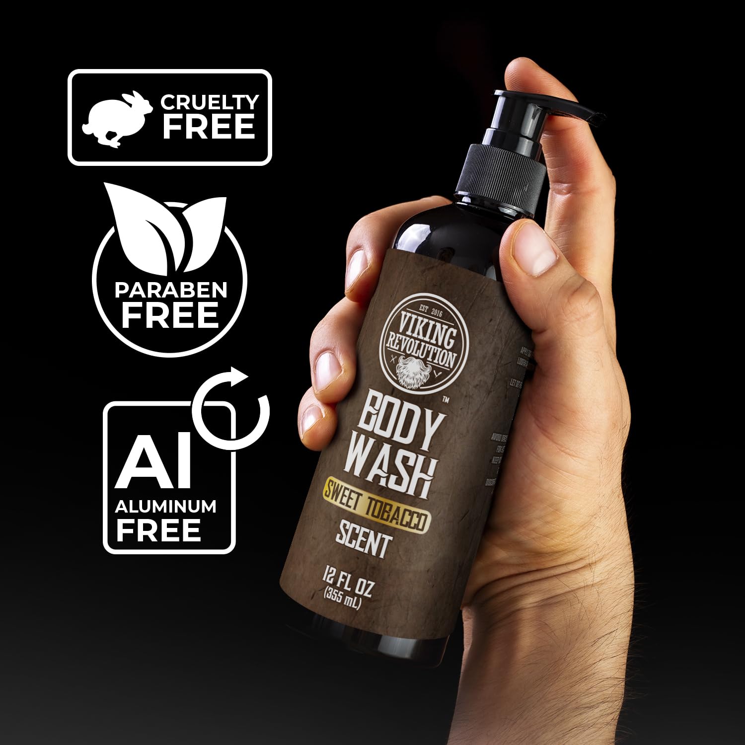 Hand holding bottle of Sweet Tobacco Body Wash, cruelty-free and paraben-free with rosemary oil labels.