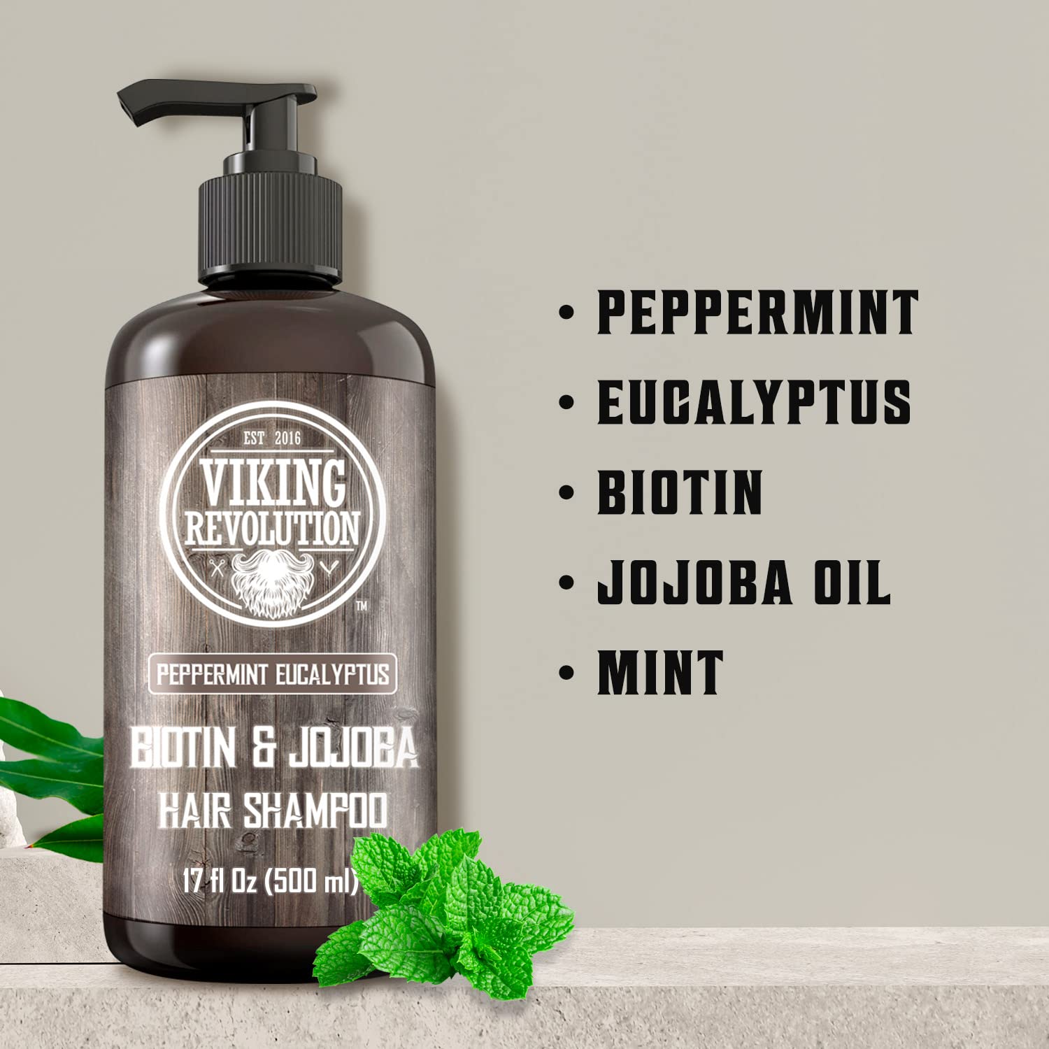 Eucalyptus and Peppermint Shampoo -17oz with biotin in pump bottle, mint leaves nearby.