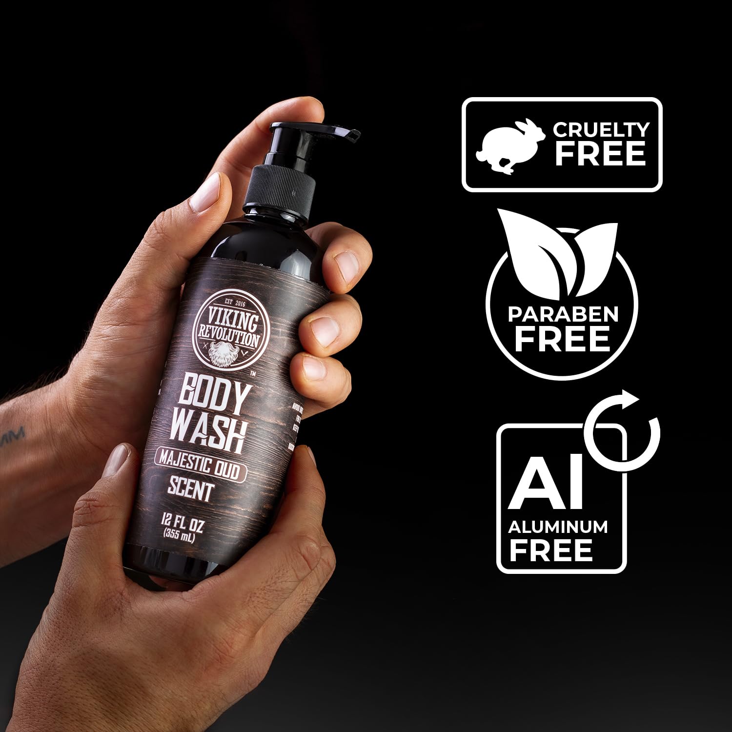 Hands holding a bottle of Viking Revolution Majestic Oud Body Wash; labels: cruelty-free, paraben-free, aluminum-free.