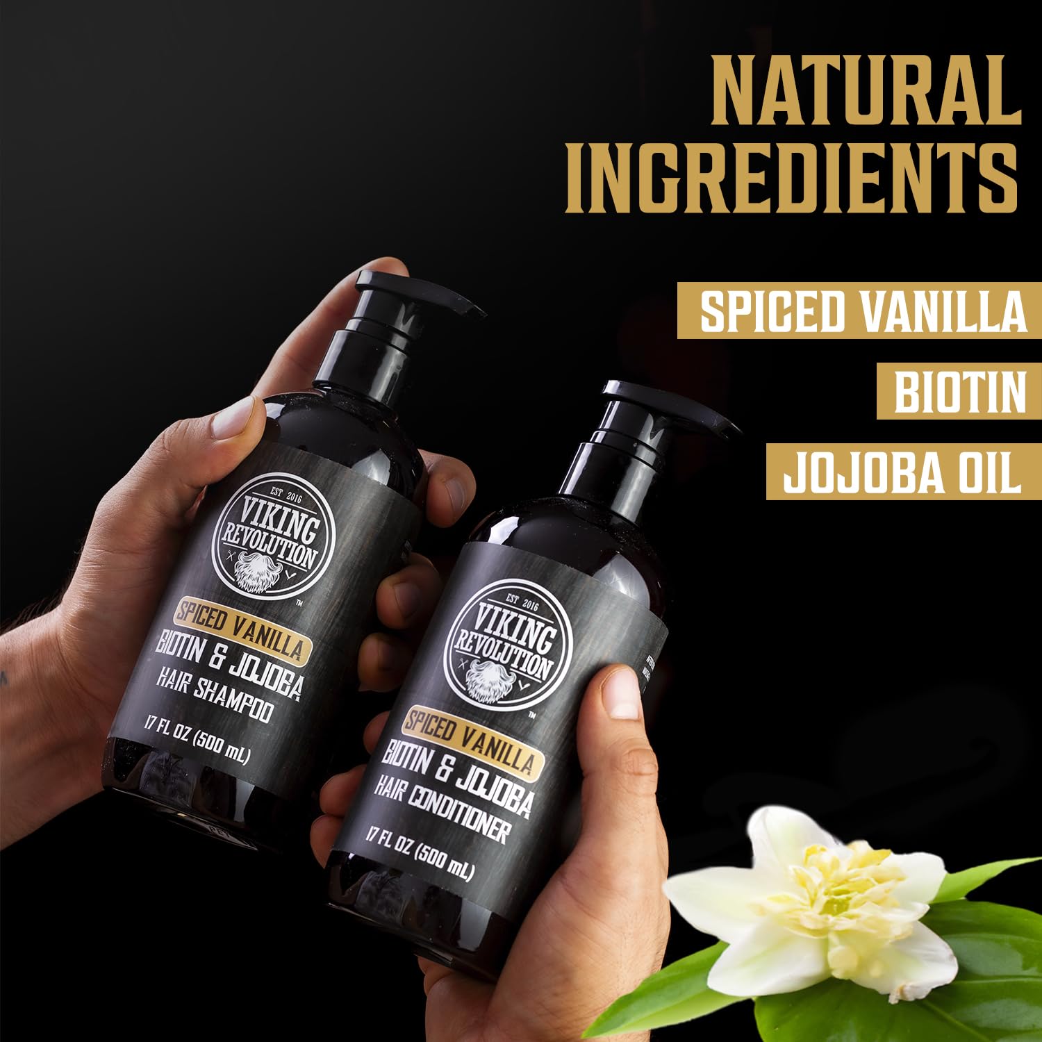 Hands holding the Spiced Vanilla Hair Shampoo & Conditioner 17oz by Viking Revolution, enriched with biotin and infused with jojoba and olive oil; flower nearby.