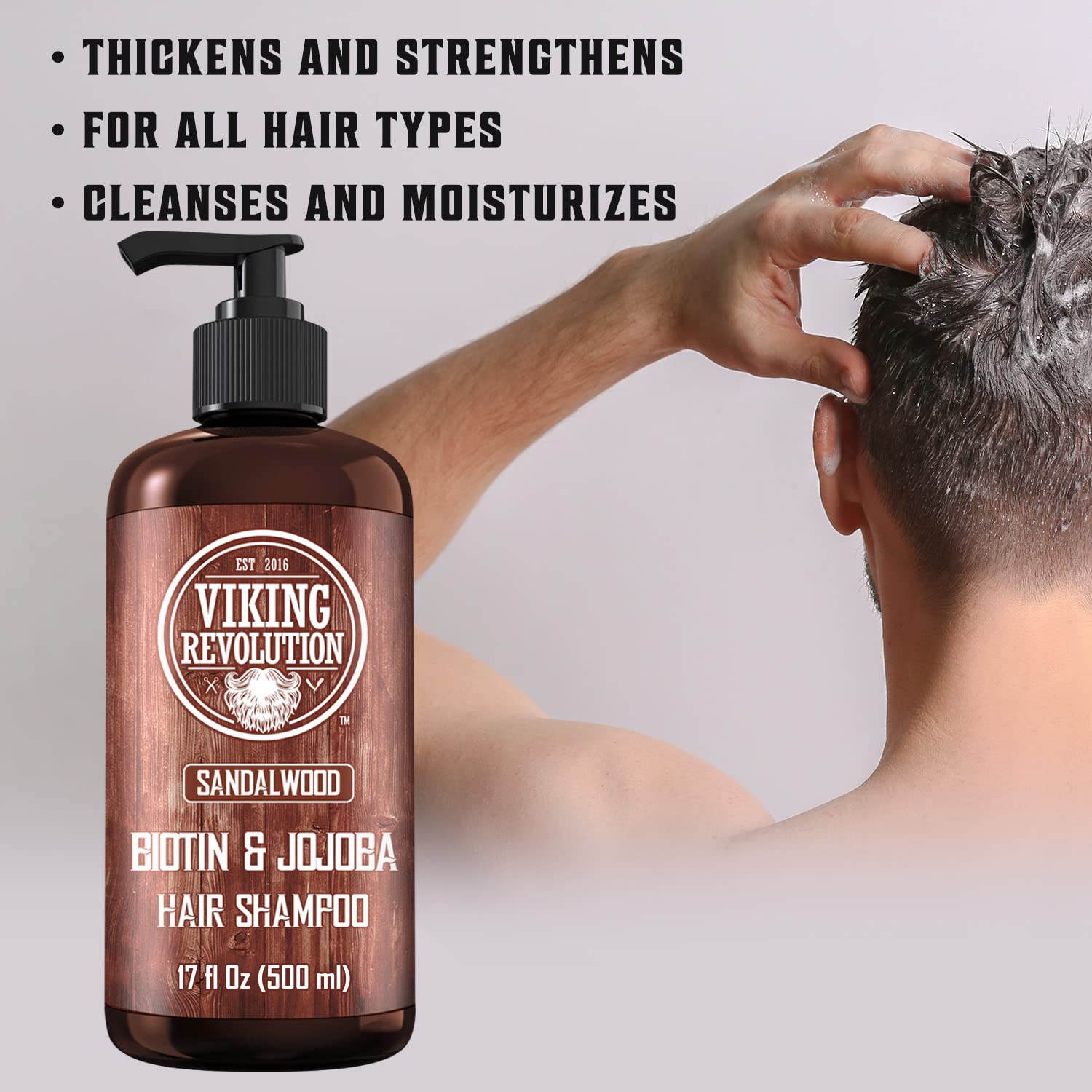 Man applying Sandalwood Mens Shampoo; sandalwood oil bottle in foreground.