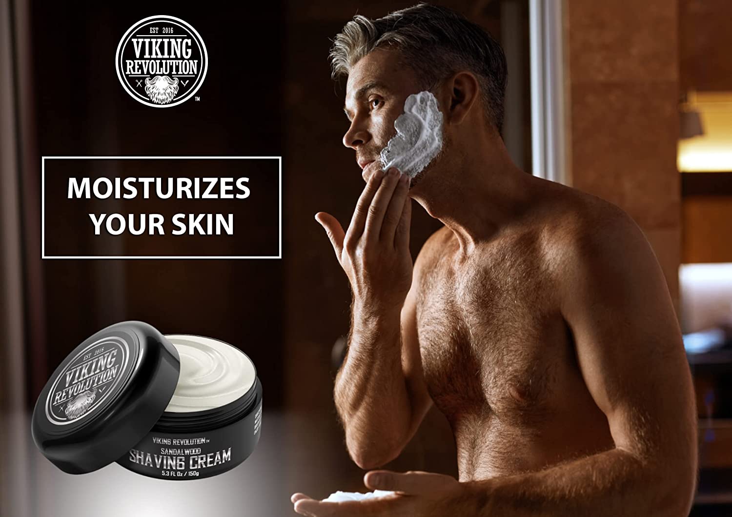 A man applies Viking Revolution - Sandalwood Shaving Cream 5.3oz, ensuring a smooth shave with its natural sandalwood oils that moisturize the skin, making it perfect for those with sensitive skin.