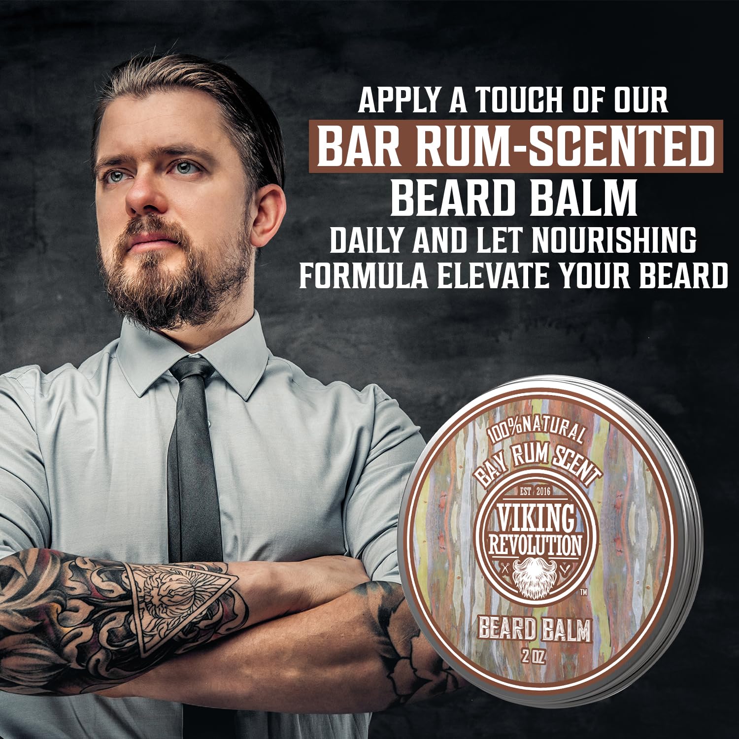 Confident tattooed man stands with Bay Rum Beard Balm, naturally scented and made from natural ingredients.