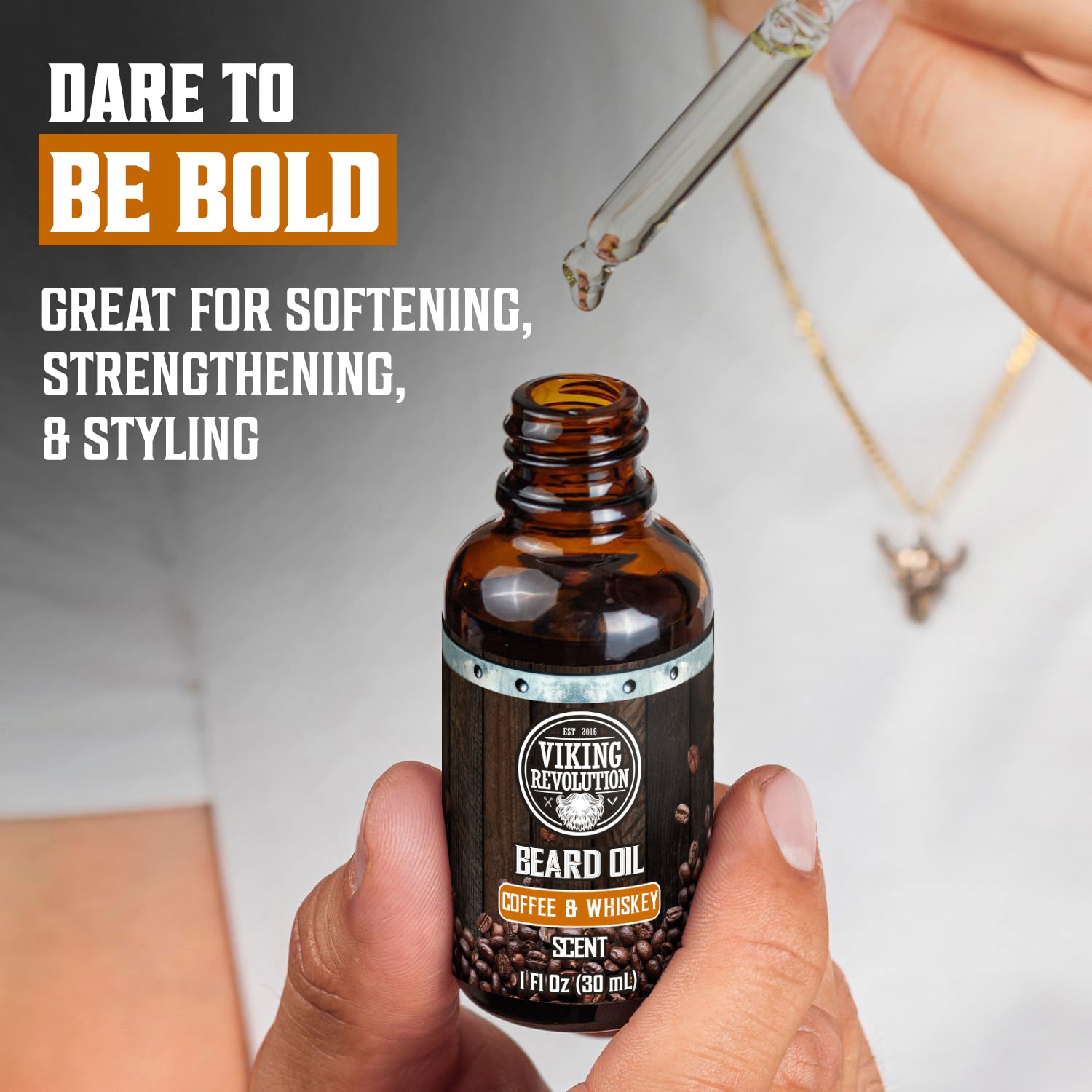 A person uses a dropper to apply Beard Care Kit - Coffee & Whiskey beard oil from the kit.