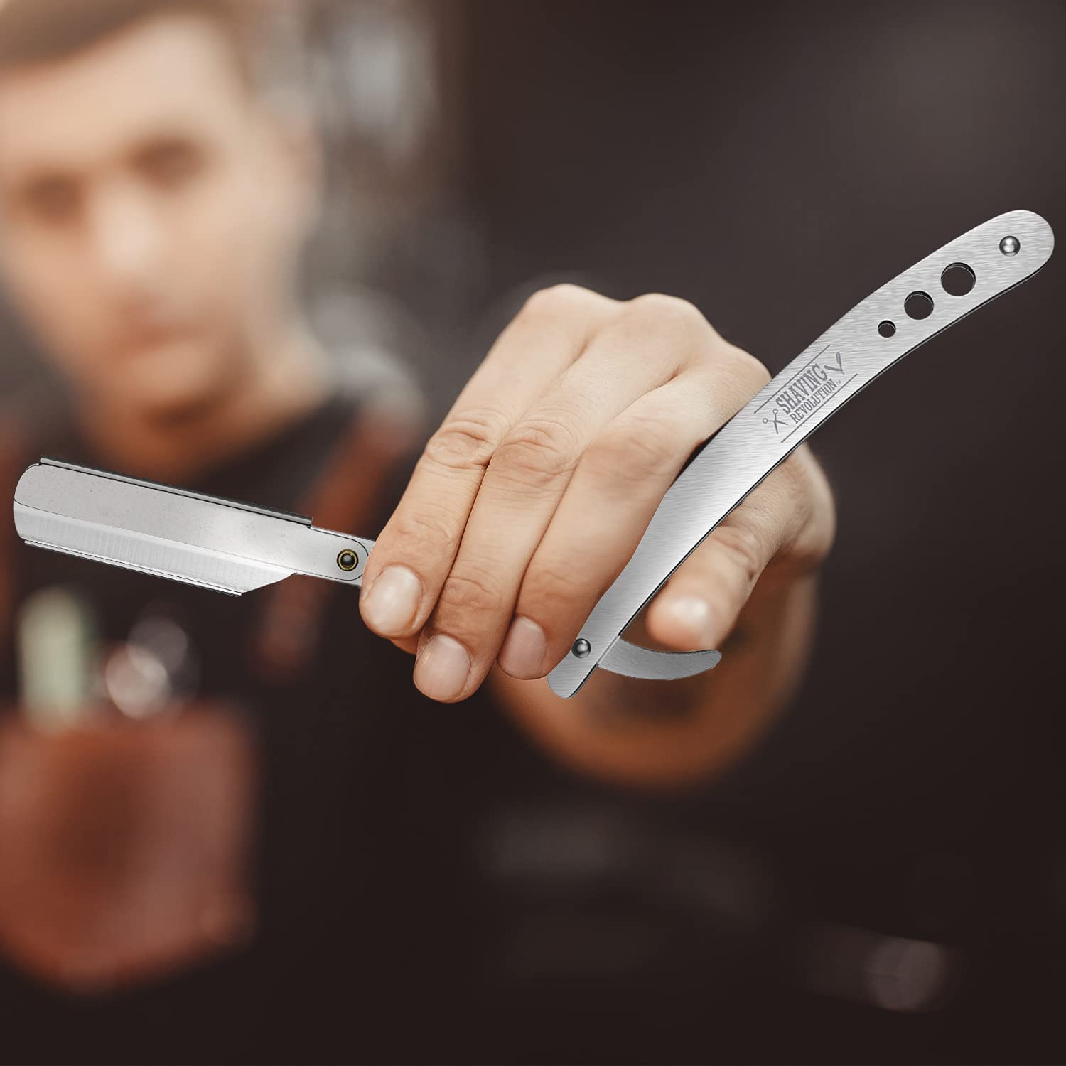 A person holding an open Straight Edge Barber Razor with the focus on the blade and a blurred background. This razor is ideal for anyone dedicated to beard care and quality grooming products.