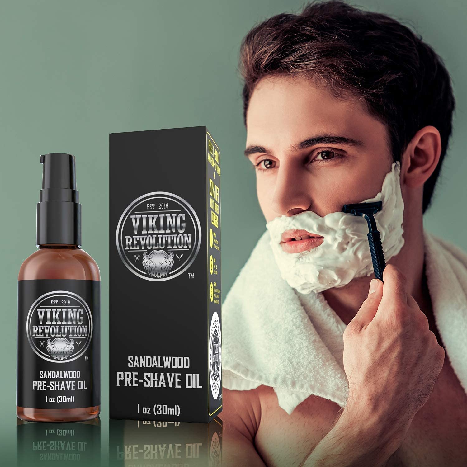 A man enjoys a clean shave, holding a razor with foam, next to the Sandalwood Pre-Shave Oil bottle and box from Viking Revolution, imbued with a rich sandalwood scent.