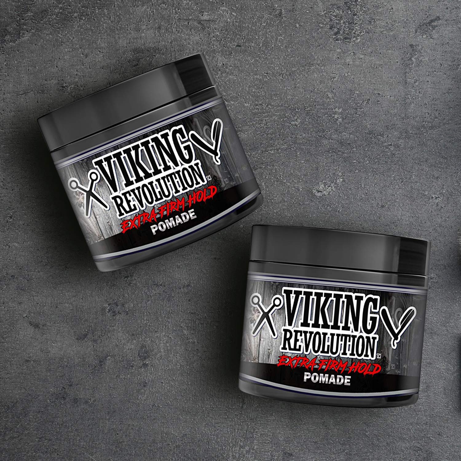 Two jars of the Pomade - 2 Pack, enriched with natural ingredients and castor oil, rest on a gray textured surface. Perfect for those who value exceptional hair grooming.