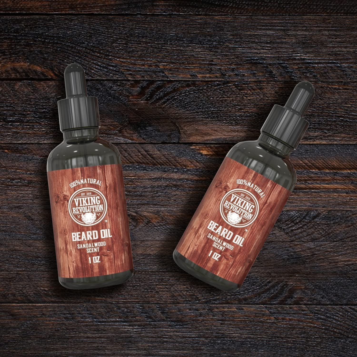 The Sandalwood Beard Oil - 2 Pack by Viking Revolution is elegantly displayed on a dark wooden surface, offering a promise of a frizz-free beard with its organic formula.