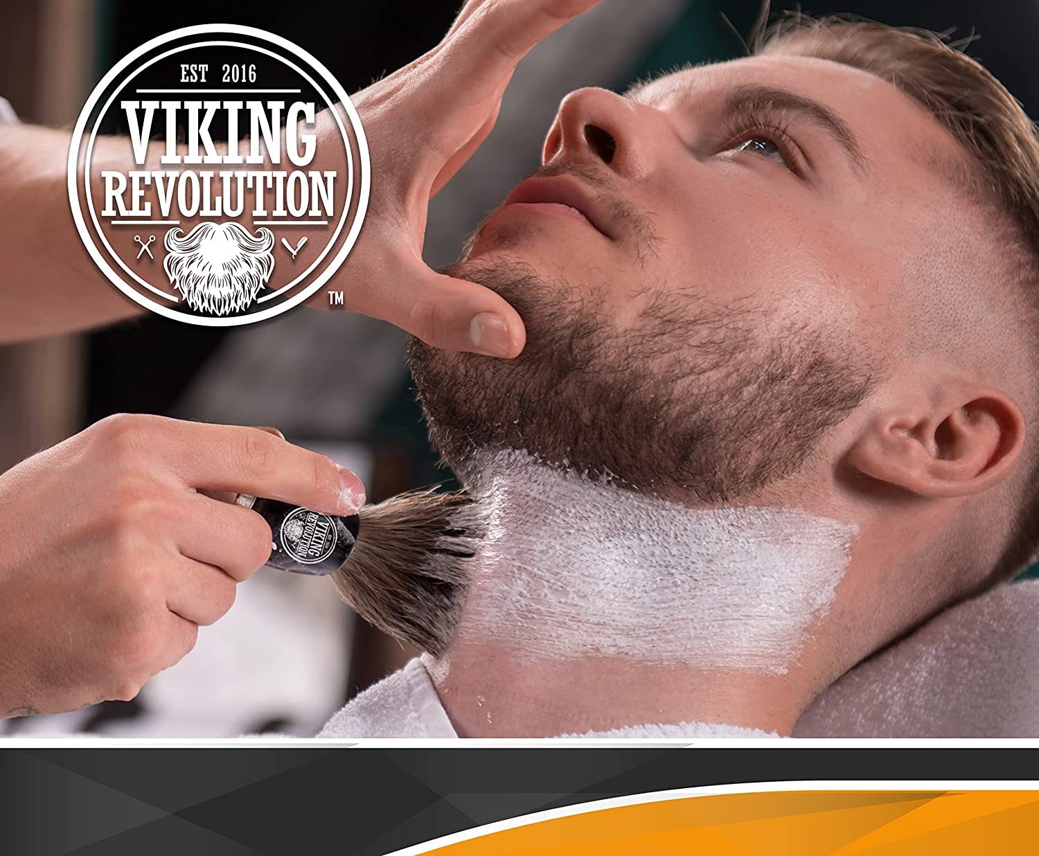 At the barber, a man indulges in a luxurious wet shave while the Viking Revolution logo is prominently featured. The shaving cream is expertly applied with the Badger Hair Shaving Brush, delivering a smooth and soothing experience.
