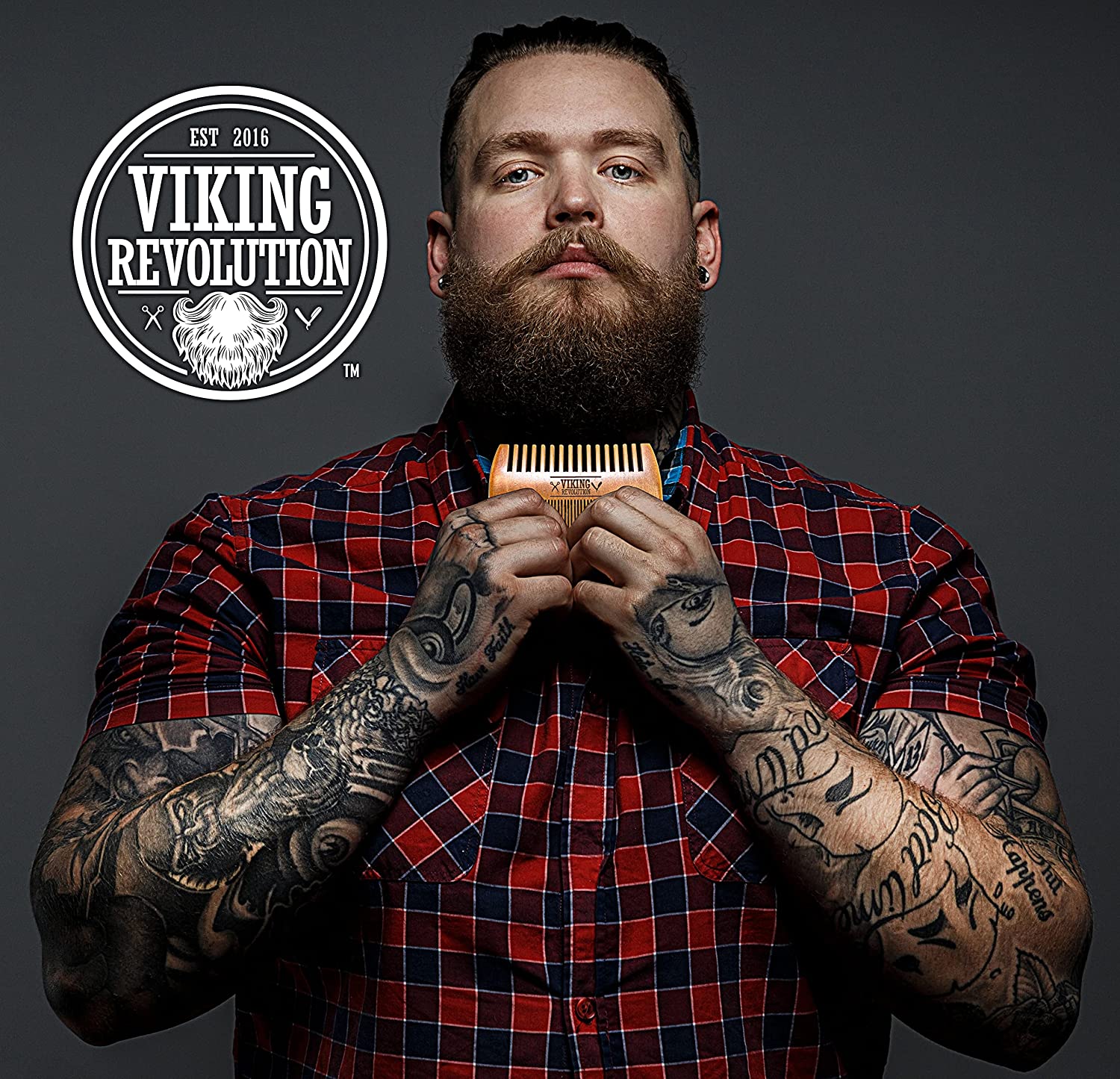 Tattooed man with a Wooden Beard Comb & Case; plaid shirt, and Grooming logo on the left.