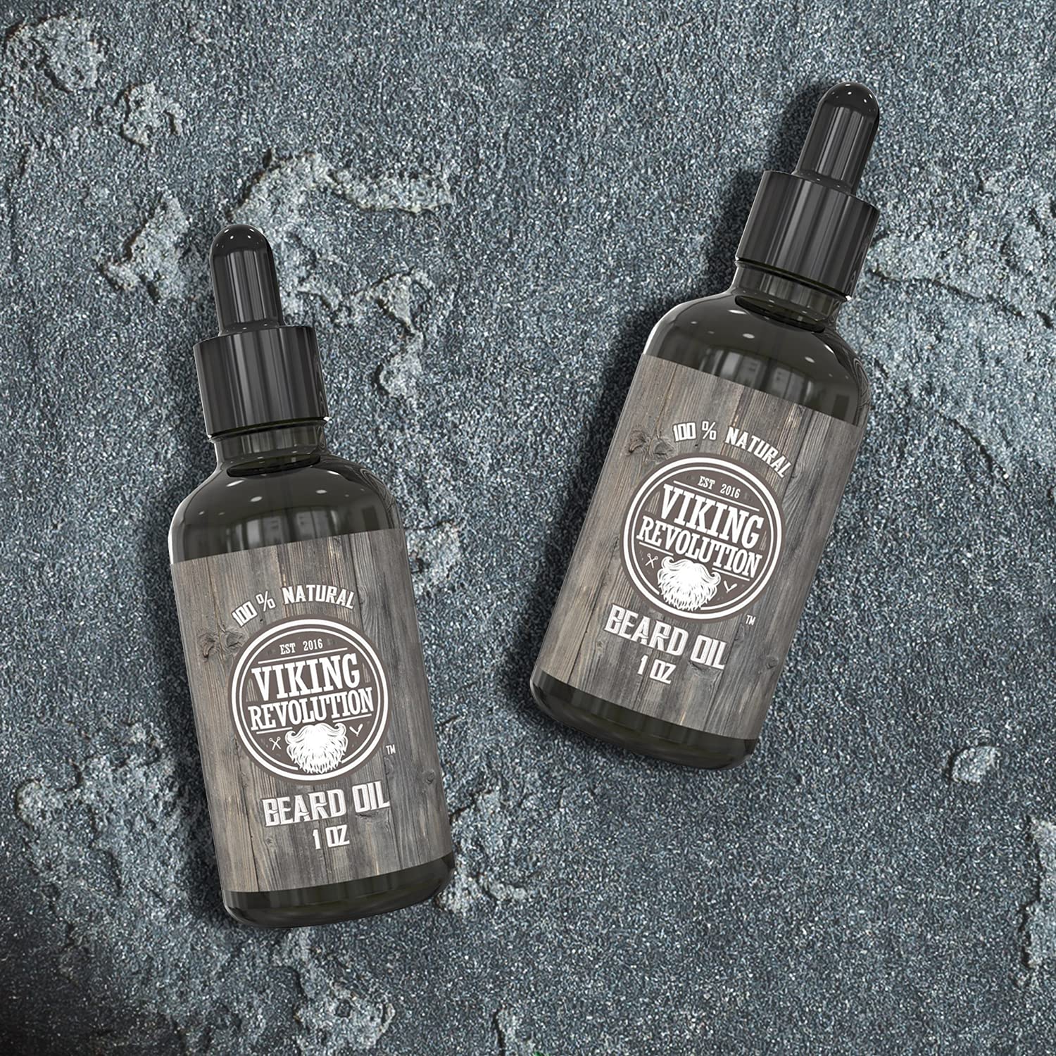 Two bottles of Viking Revolution Unscented Beard Oil on a textured stone surface.