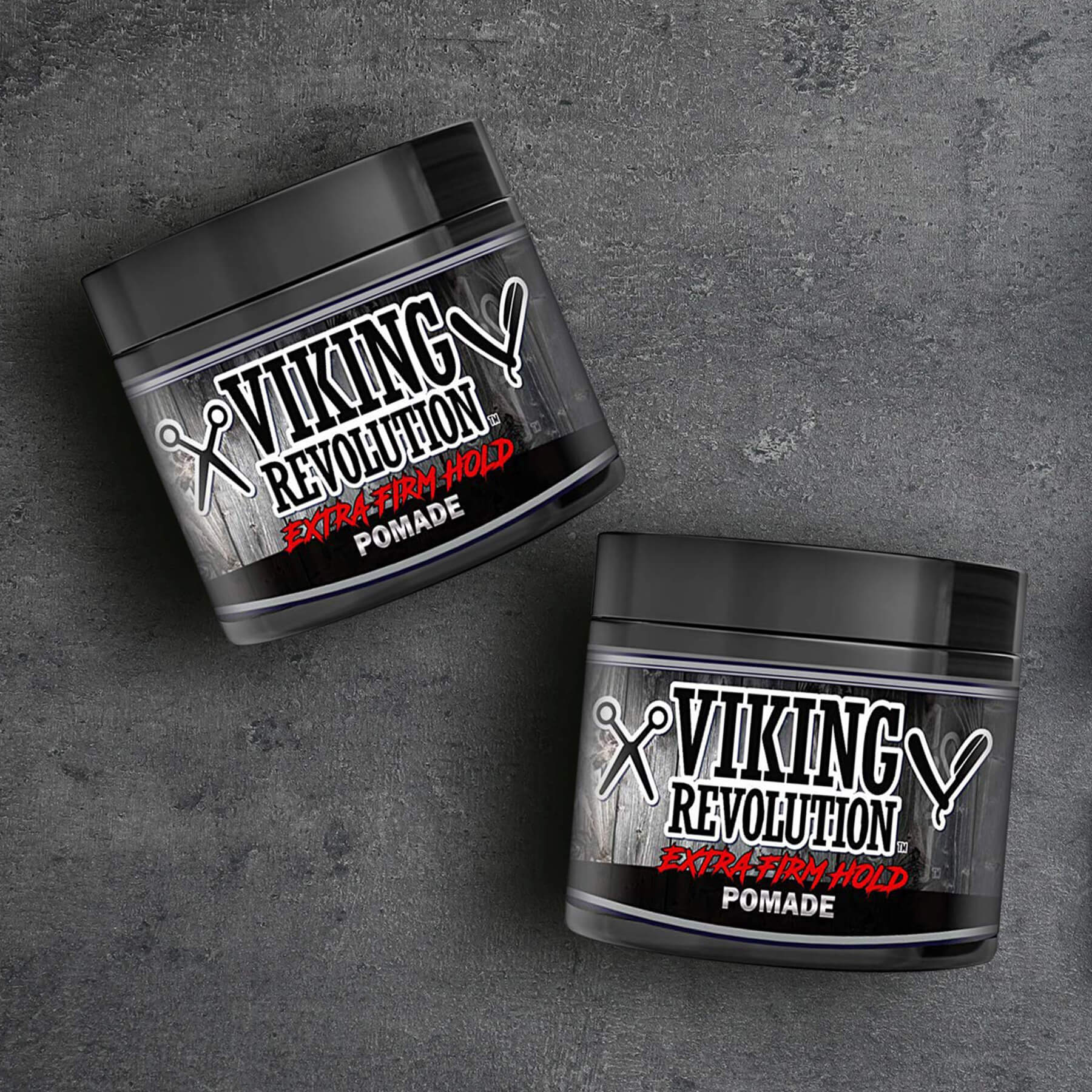 Two jars of Extreme Hold Hair Pomade for a shiny look on a dark textured background.