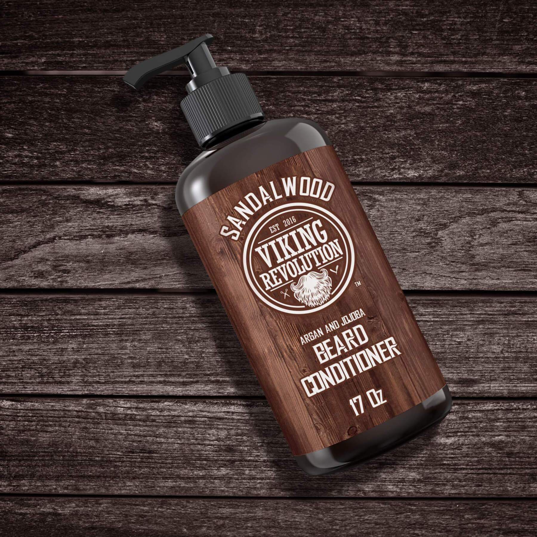 A bottle of Beard Conditioner 17oz by Viking Revolution, enriched with natural beard oil for healthy beard growth, sits elegantly on a wooden surface.