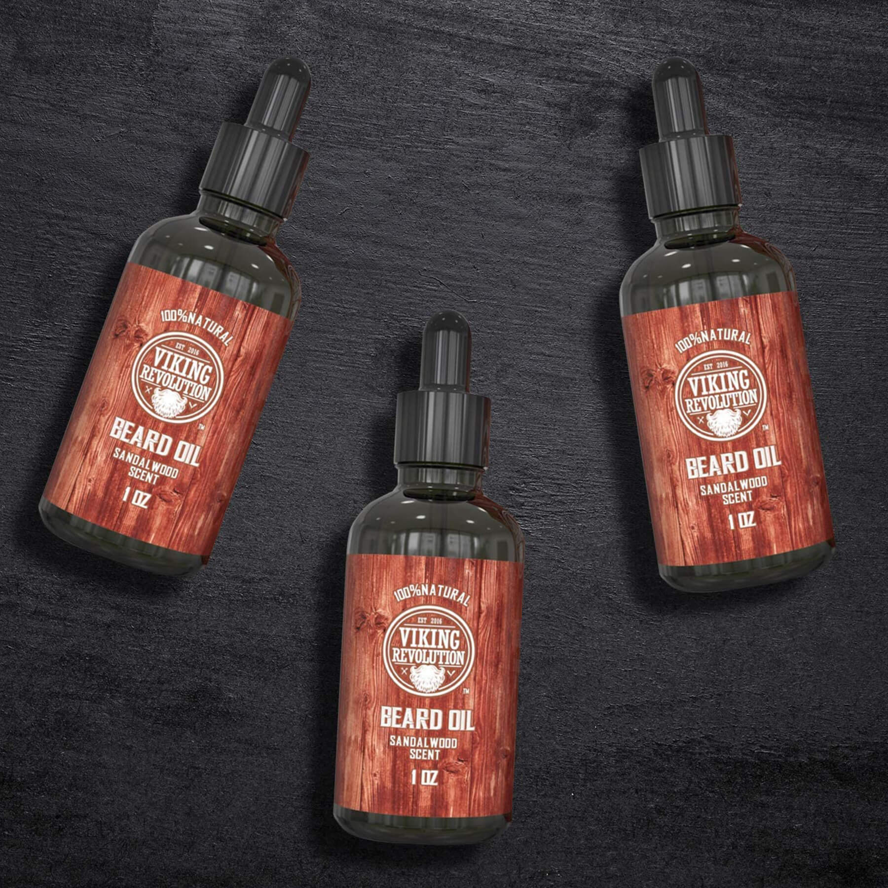 A 3-pack of Sandalwood Beard Oil, renowned for its ability to tame stubborn facial hair and sandalwood scent, rests elegantly on a dark surface.