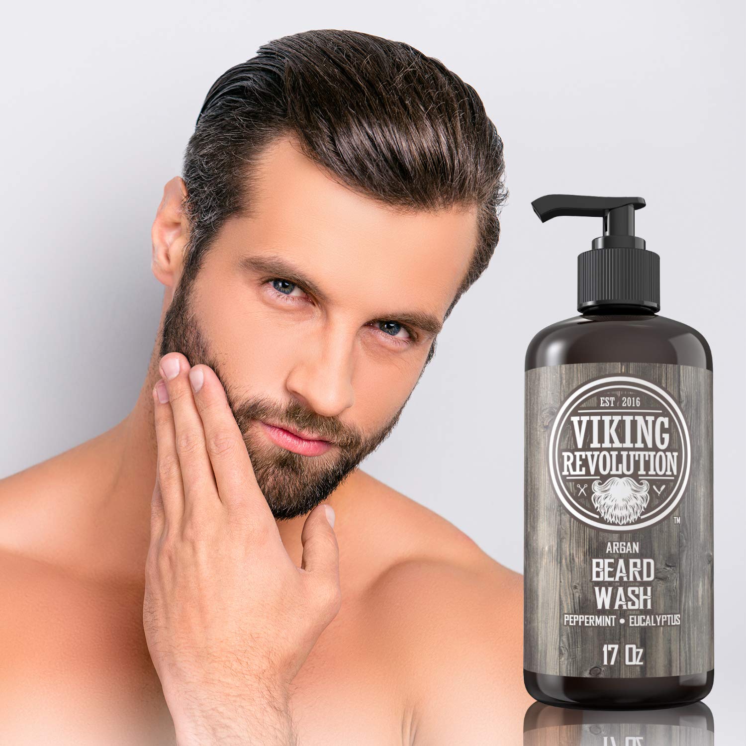 Man touches his beard beside a bottle of Beard Wash - Peppermint & Eucalyptus (17oz).