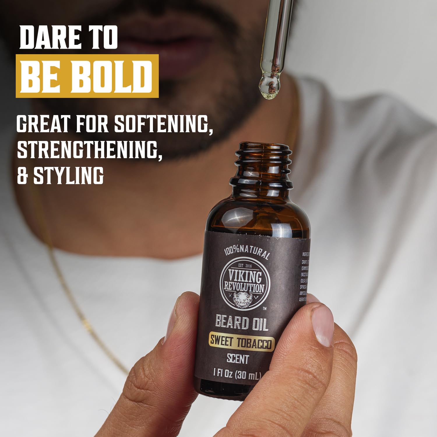 A man holds a dropper of Sweet Tobacco Beard Oil for Men - 1 Pack, known for natural beard care.
