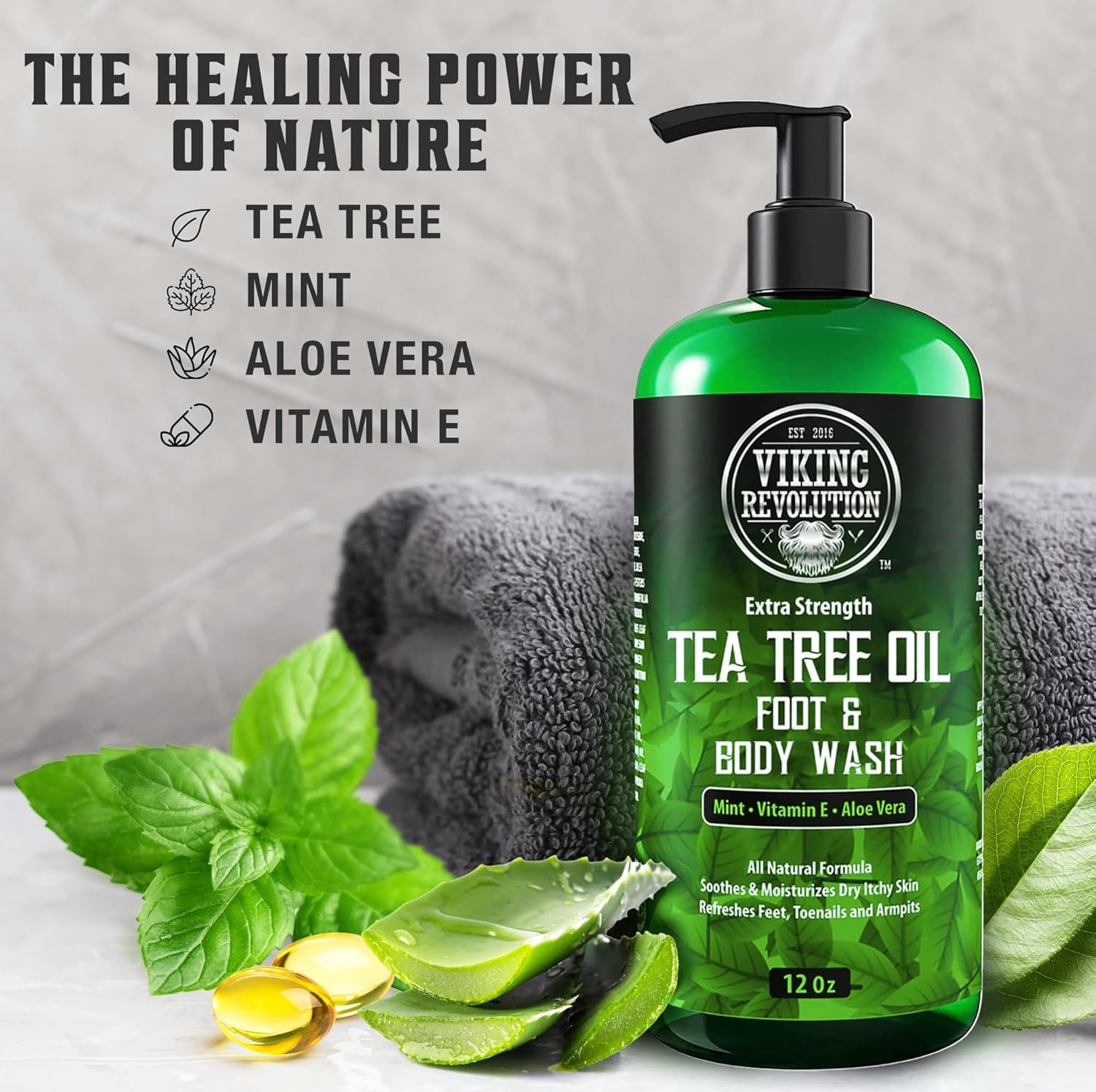 A 12oz Tea Tree Oil Body Wash with towels, mint, and aloe arranged beside it.