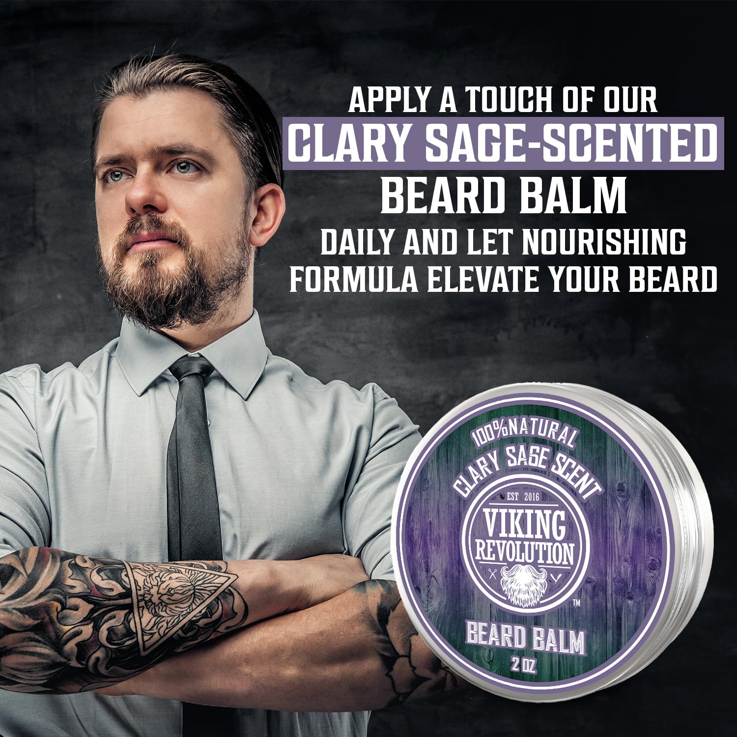 Bearded, tattooed man stands confidently beside a tin of Clary Sage Beard Balm (2oz).