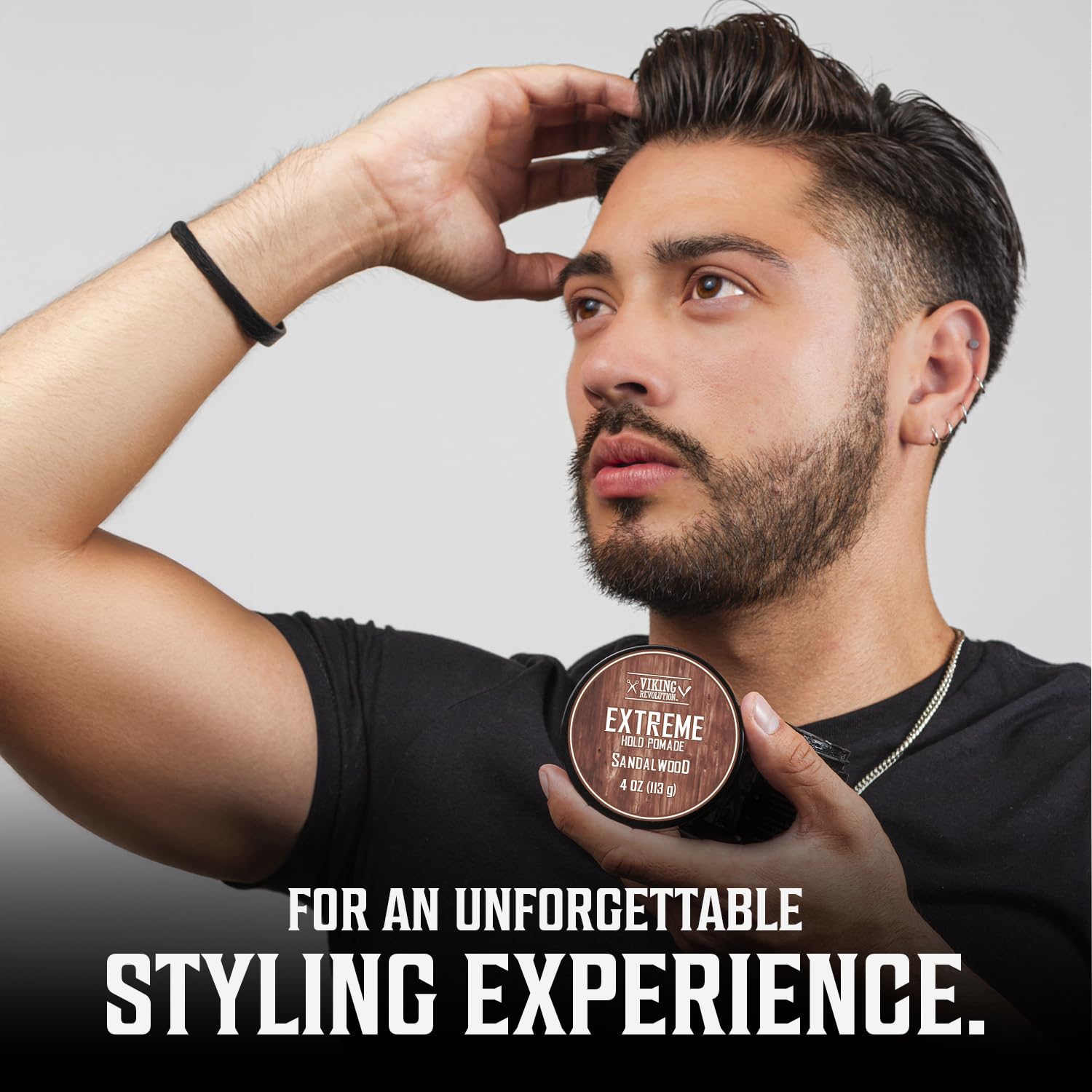 Man styling hair, holding Sandalwood Hair Pomade (4 oz) jar, for an unforgettable experience.
