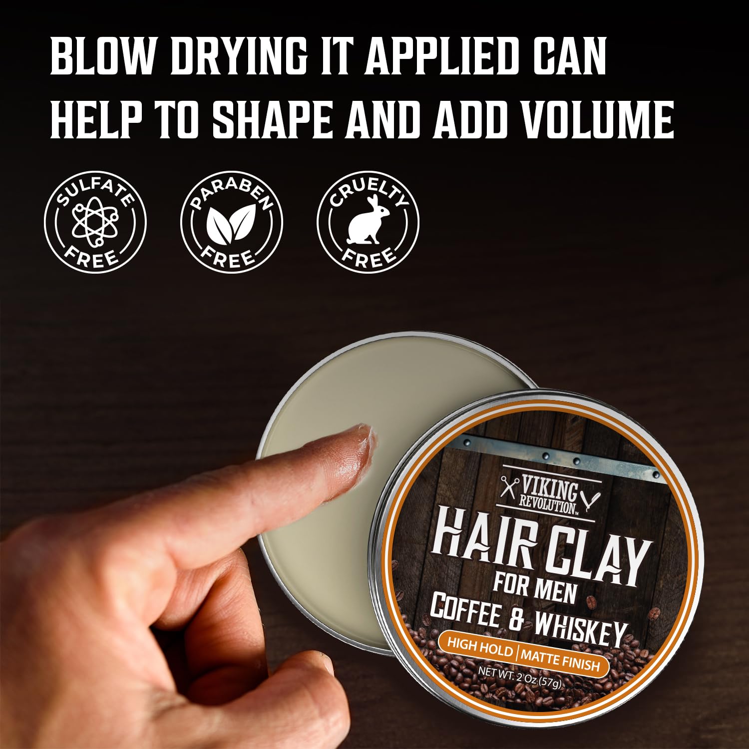 A hand touches Hair Clay - Coffee & Whiskey; text highlights its volume and cruelty-free formula.