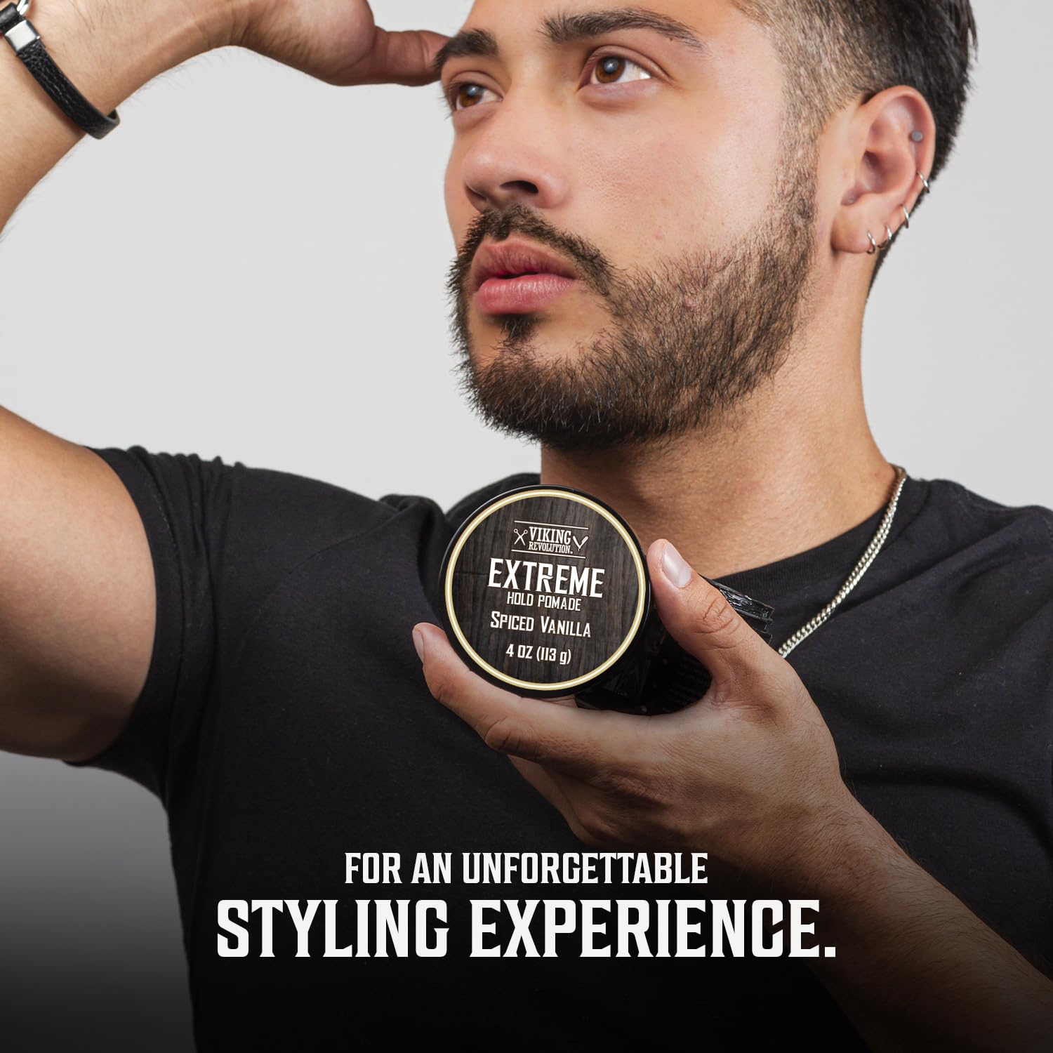 A man holding New Scents Hair Pomade with extreme hold in Spiced Vanilla flavor near his head, showcasing a high-shine finish, with the tagline below.