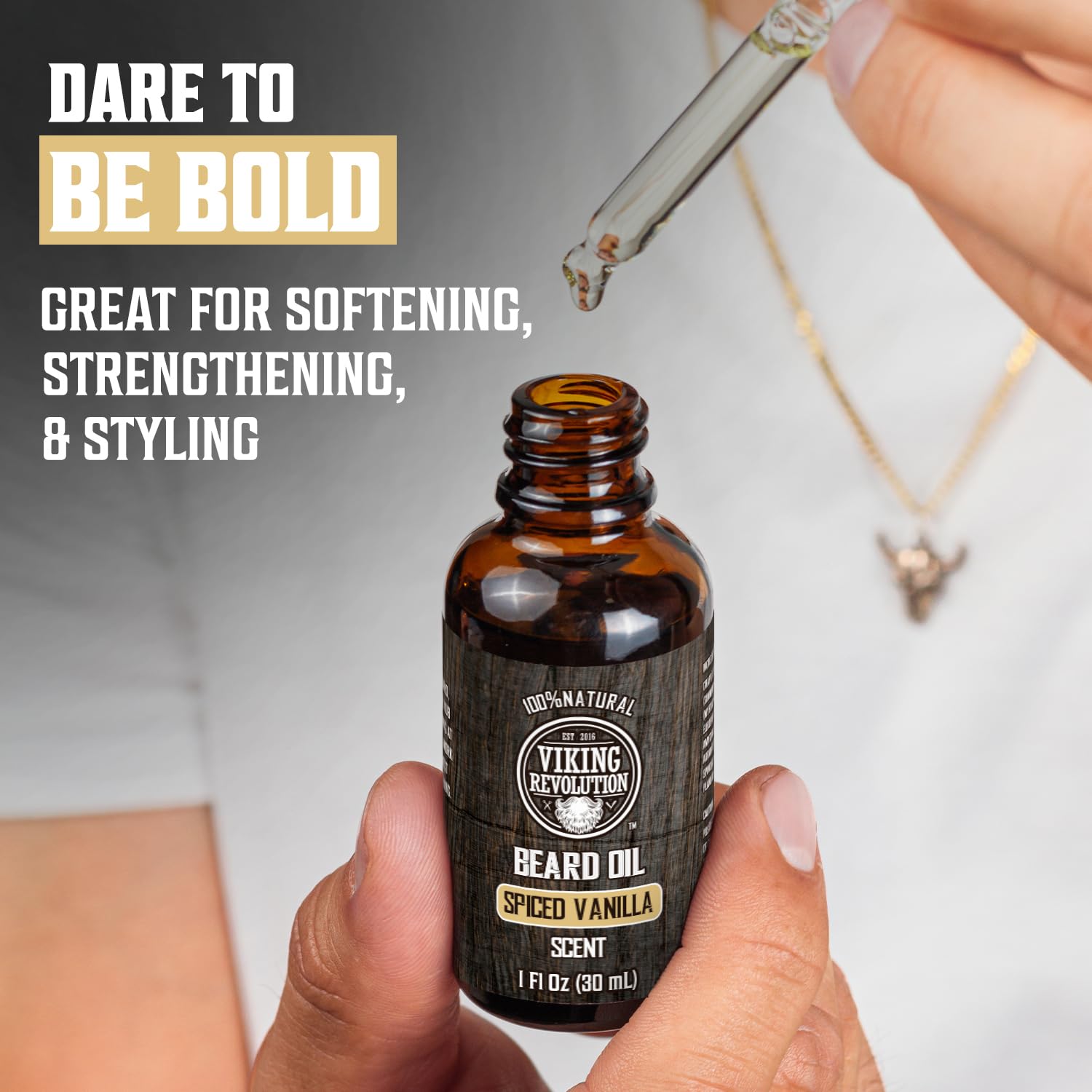 Person holding a dropper of Spiced Vanilla Beard Oil. Text: Dare to Be Bold with spiced vanilla scent.