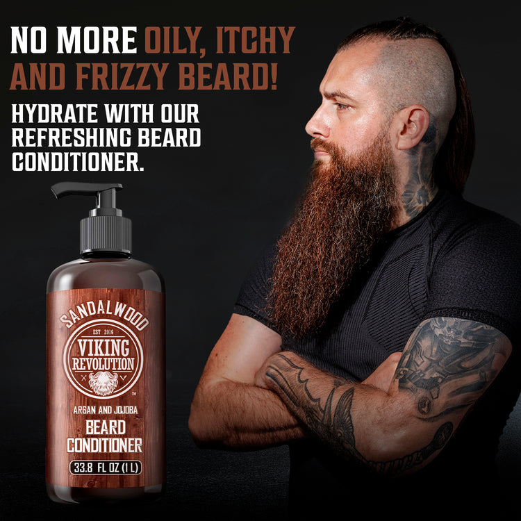 Tattooed man with long beard holds a 33.8 fl oz bottle of Sandalwood Beard Conditioner for growth.