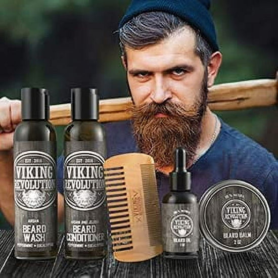 A bearded man holding an axe stands amidst a collection of products from the Viking Revolution - Beard Care Kit, Classic, featuring a nourishing beard conditioner crafted with natural ingredients.