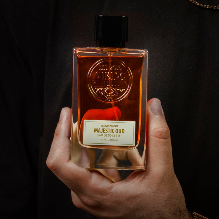 Person holding Majestic Oud Cologne for Men, 3.5 Fl Oz bottle against a dark background.