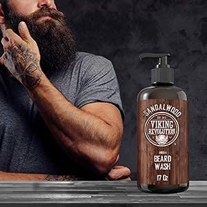 Tattooed man with a beard; Sandalwood Beard Wash 17oz with natural ingredients in the foreground.