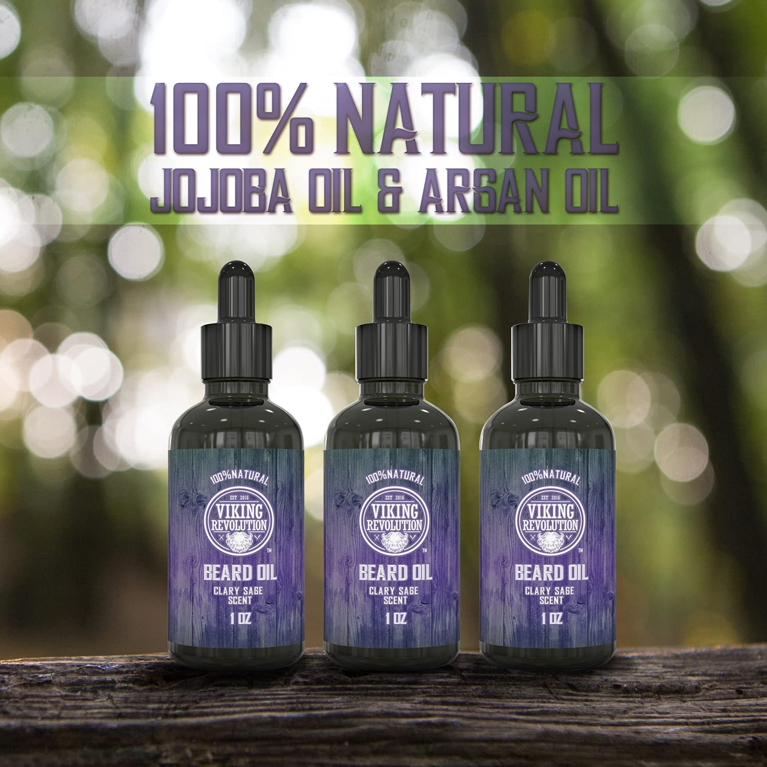 Three bottles of Clary Sage Beard Oil - 3 Pack rest on a wooden surface, forest backdrop.