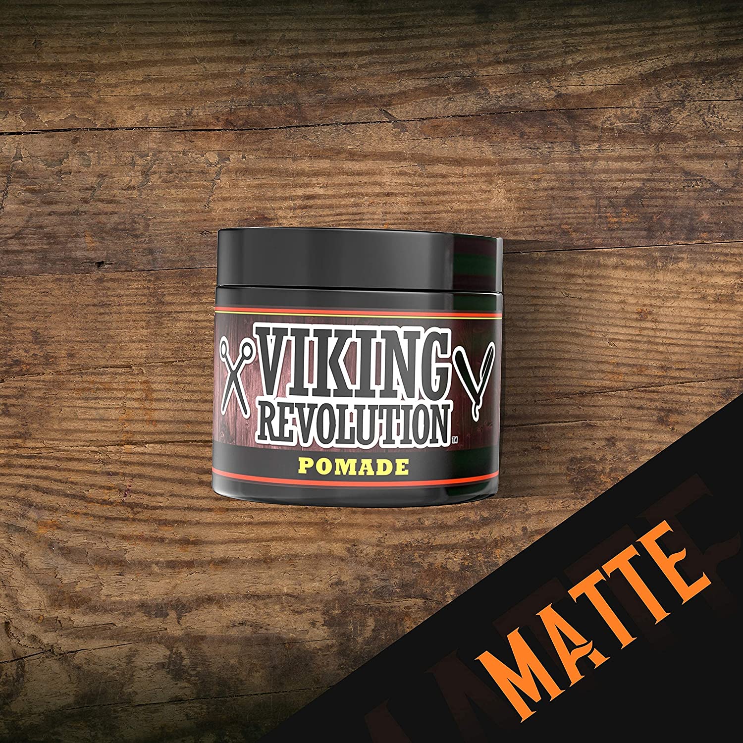 A jar of Medium Hold Hair Pomade 4oz sits on a wooden surface, offering easy hair styling with its natural matte finish.
