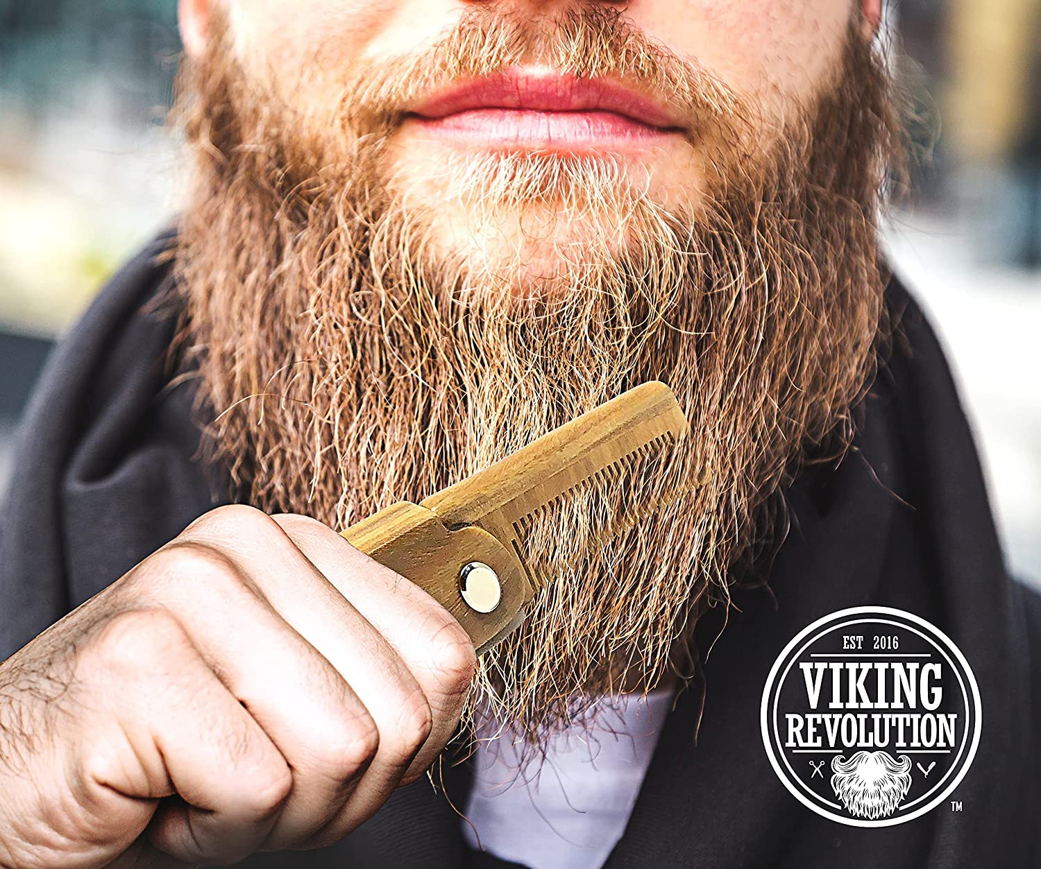 A man expertly combs his long, thick beard using the Folding Beard Comb with Carrying Pouch from Viking Revolution, guaranteed to provide premium beard grooming satisfaction.