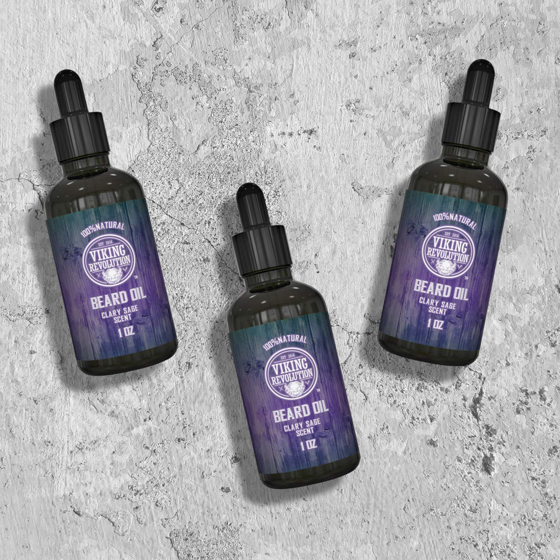 Three bottles of Clary Sage Beard Oil - 3 Pack by Viking Revolution on a textured gray background.
